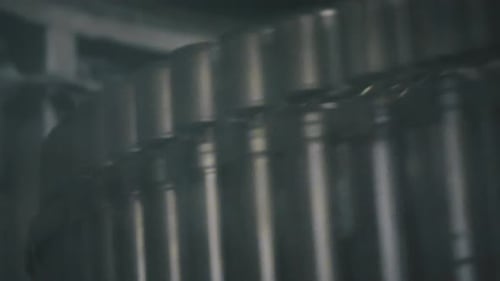 Aluminum cans rotating on conveyor belt in beverage factory