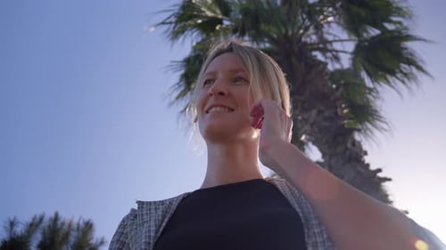 Woman putting on wireless headphones, getting ready for evening walk