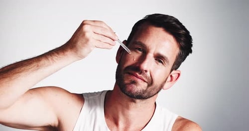 Face, serum and man with skincare, cosmetics and dermatology on white studio background