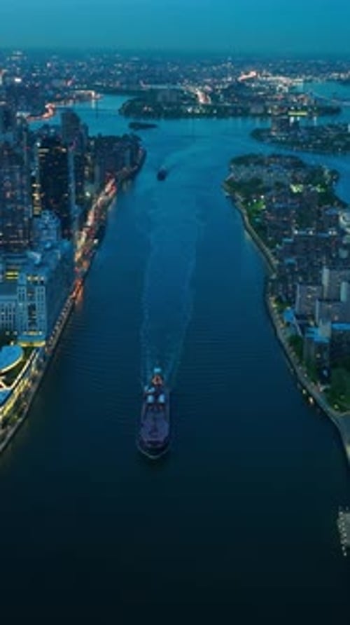 Boats moving by the calm river in beautiful New York. Evening time with lights