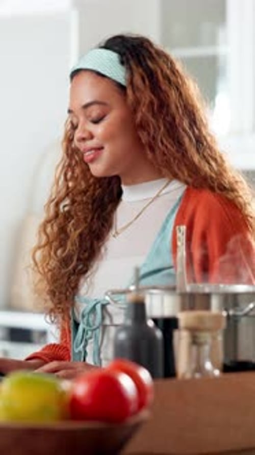 Woman Stirs Food in Pot in Kitchen