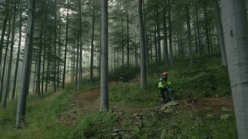 Professional Mountain Bikers Going Downhill In Mountains