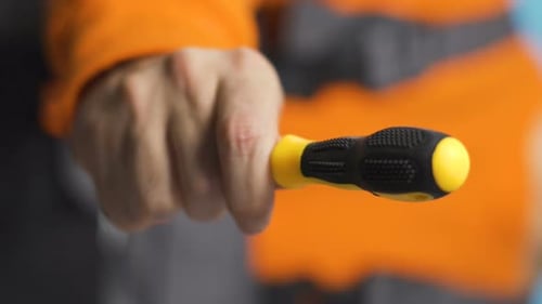 Handing Off Screwdriver with Blurry Vertical Video of Repairman in Industrial Work Clothes