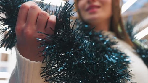 Woman Holds Blue Christmas Tinsel Close Up