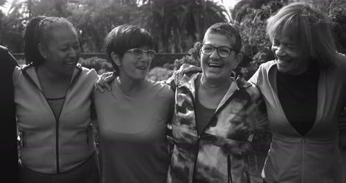 Smiling adults embrace outside in a park
