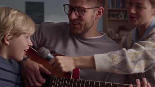 Family sings and plays guitar at home