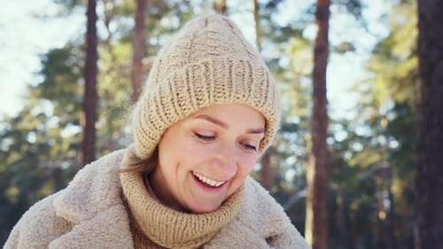 Happy Beautiful Young Woman Playing in the Winter Forest with Her Afghan Hound Dog on a Winter Day