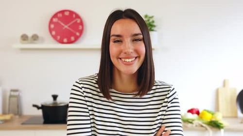 Smiling Woman in Kitchen Looking at Camera