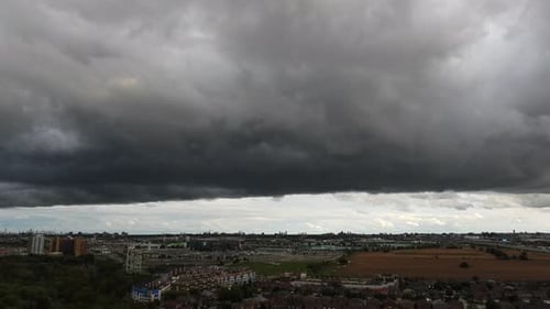 time lapse of the dark clouds passing to form a huge thunderstorm above a city