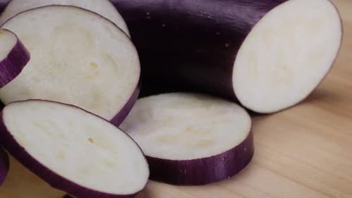 Cutting Slice of a Violet Eggplant is Placed on a Wooden Cutting Board Showcasing the Beauty of This