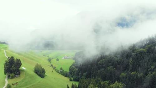 Aerial of Misty Mountain Valley next to Green Forest with Clouds