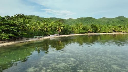 Tranquil Tropical Cove in the Philippines: Clear Water, Boats, and Lush Green Hills
