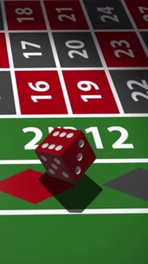 Red dice rolling on green roulette table with numbered betting grid.