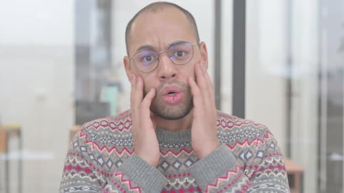 Portrait d'un homme métisse réagissant à un échec