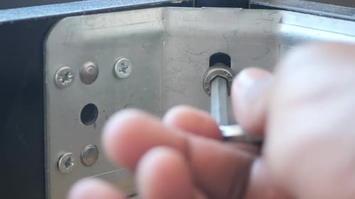 Using a Wrench Theyre Removing a Screw From Metal