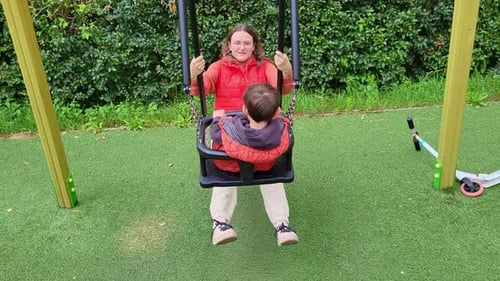 Mutter und Kind schaukeln gemeinsam auf dem Spielplatz und schaffen so schöne Erinnerungen an den Sommerspaß.