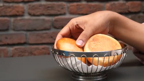 Women Hand Pick a Baked Bread on Table