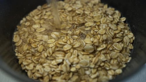 Adding Water to Oats in a Bowl