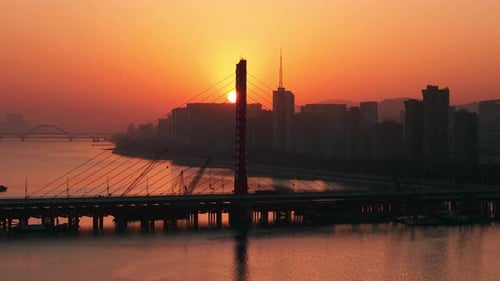 Beautiful Sunset Over the River with Orange Glow Reflecting on Water and Bridges