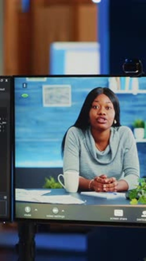 Remote Worker on Video Call with Two Monitors
