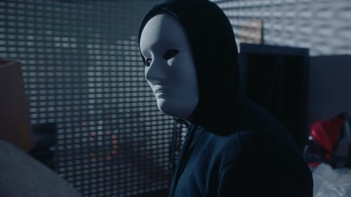 Masked Murderer or Thief Posing for Camera in Dark Garage at Night