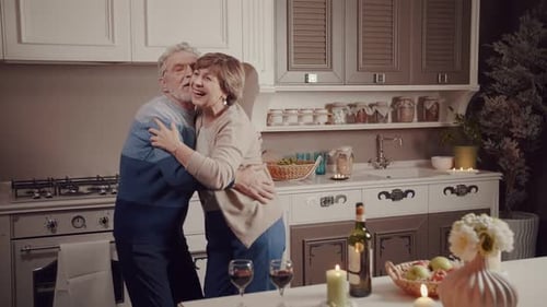Senior Couple Dancing in Kitchen Embracing Lovingly