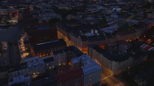 Aerial Cinematic View of Buildings in Evening City Illuminated Streets in Urban Borough Helsinki