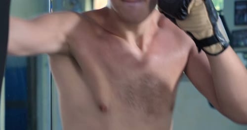 A professional boxer, work out blows, in a good body, elastic bandages, punches bag. Concept: to l