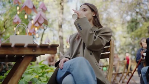Young Woman Enjoying a Peaceful Coffee Break in a City Park