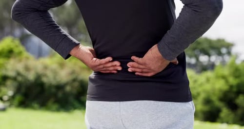 Adult Holding Sore Lower Back Outdoors