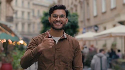 Smiling Man Giving Thumbs Up in City Street