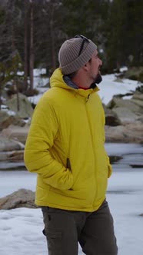 Hiker Walking in Snowy Mountain Forest Trail with Backpack and Trekking Poles