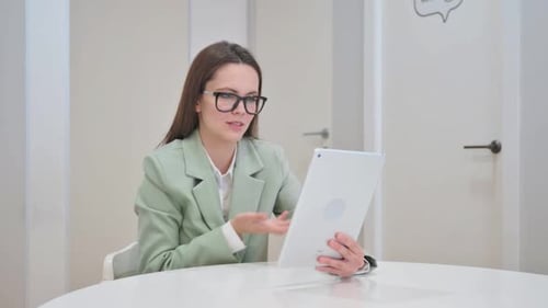 Woman Smiling During Tablet Video Call at Work