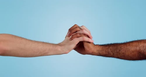 Holding hands, love and support in diversity and isolated in studio by blue background