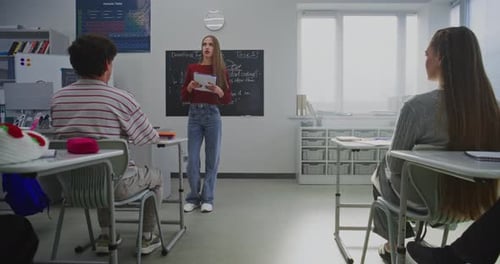 Teacher Explaining Lesson to Students in Classroom