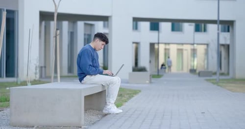 Student Working on Laptop Outside University Building