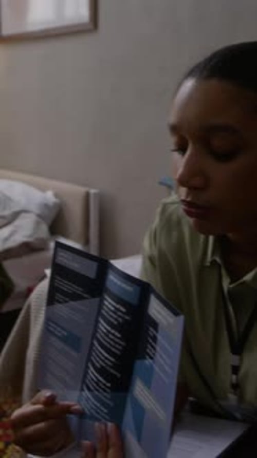 Vertical of Caregiver Showing Brochure with Social Service Program to Senior Man
