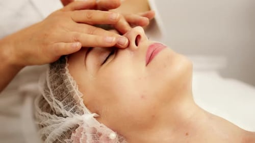 Woman Receiving a Facial Massage in Spa Setting