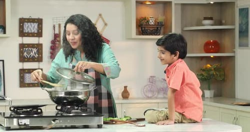 Woman Cooking with Child in Bright Modern Kitchen