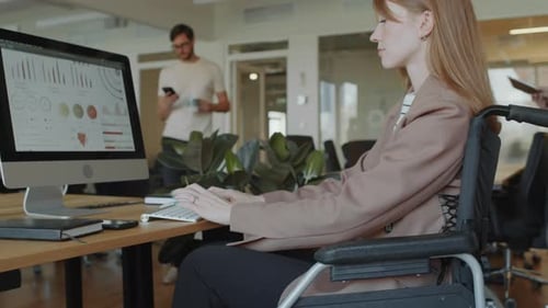 Businesswoman Working on Financial Report on PC at Office Desk