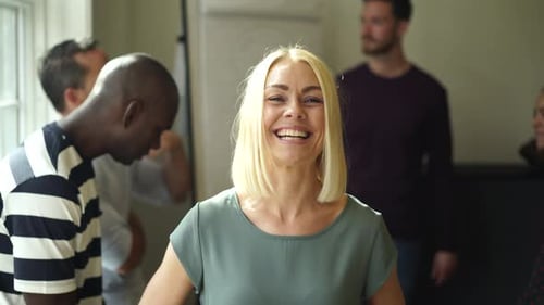 Young businesswoman laughing with colleagues in a modern office boardroom