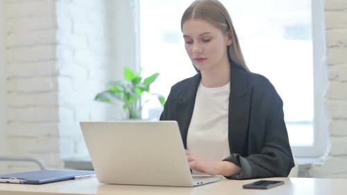 Woman Works on Laptop in Bright Office