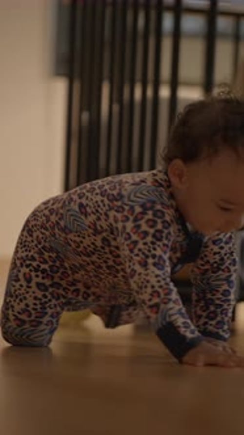 Eine entzückende Szene, in der ein krabbelndes Baby freudig mit einem Spielzeugauto auf dem Boden spielt
