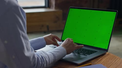 Person Typing on Laptop with Green Screen
