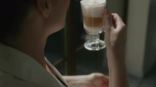 Woman Drinks Layered Coffee Beverage
