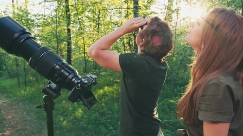 Observation des
oiseaux dans le parc. Couple observe les oiseaux avec des jumelles et un appareil photo avec téléobjectif. Oiseau amateur