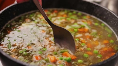 Homemade Chicken Vegetable Soup Cooking Close Up View of Chef Cooking Vegan Healthy Soup in Big Pan