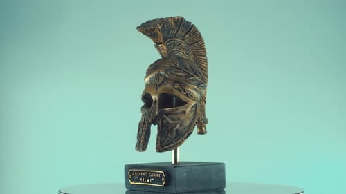 A rotating close up shot of a spartan warrior ancient greek metal bronze helmet, with shapes and for