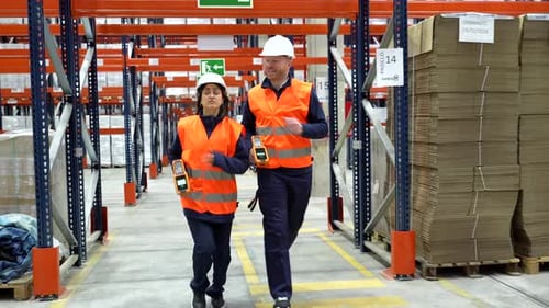 Logistics operators walking in warehouse