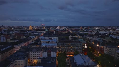 Forwards Fly Above Large City at Dusk Evening Footage of Buildings in Metropolis Helsinki Finland